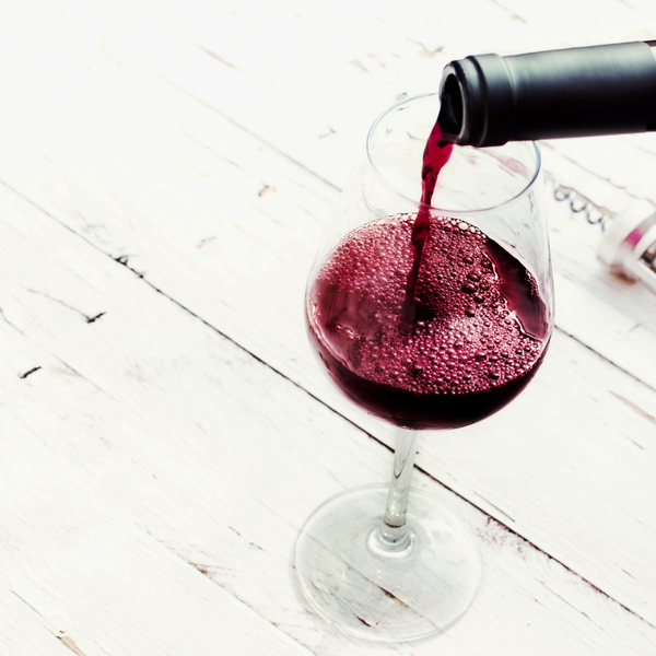 Rotwein wird ins Glas eingeschenkt.